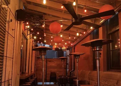 A patio with tables and chairs and a ceiling fan.