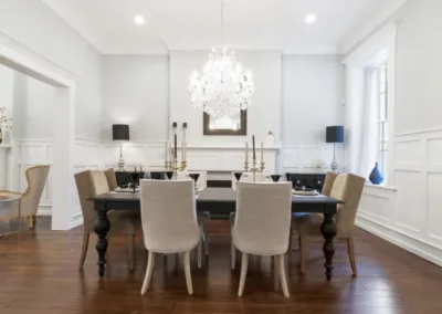 A dining room with hardwood floors and a chandelier.